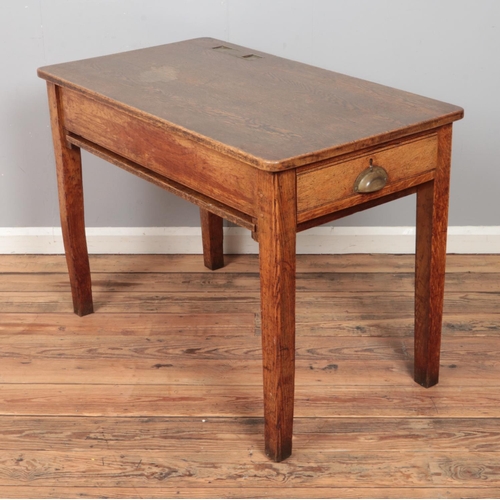 318 - A 1940's teachers desk in oak with brass plated ink wells and glass inserts, draw to either side wit... 