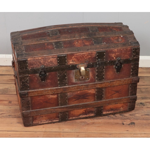 320 - A wood-bound leather dome-top steamer trunk with geometric motifs. 

Hx55cm
Wx72cm
Dx43cm