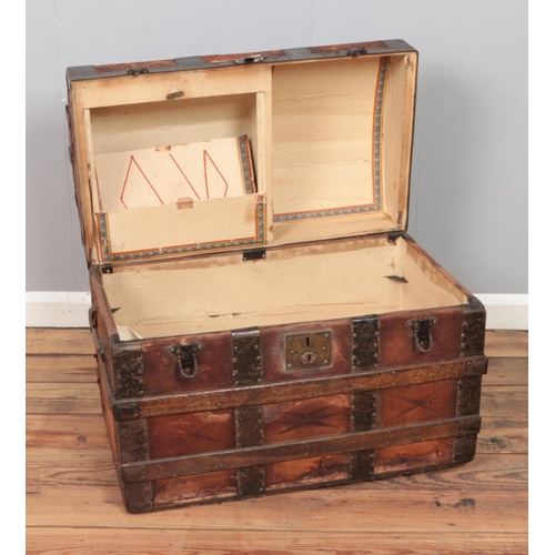 320 - A wood-bound leather dome-top steamer trunk with geometric motifs. 

Hx55cm
Wx72cm
Dx43cm