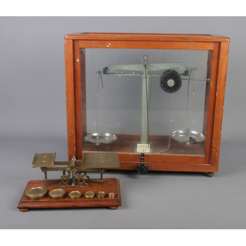 137 - A cased set of chemical scales along with vintage brass postal scales with weights.