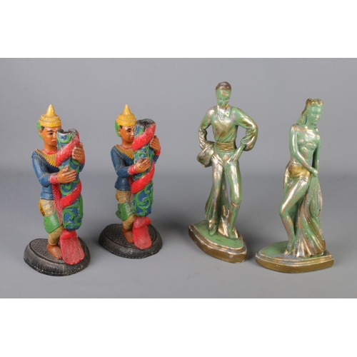 138 - A pair of wooden carved candle sticks depicting eastern figures. Together with two Art Deco style pl... 