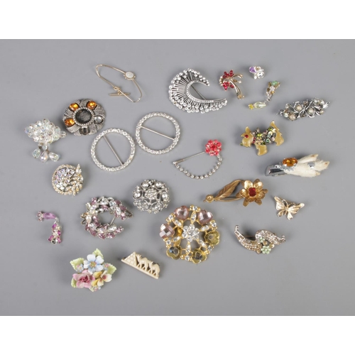 7 - A collection of costume jewellery brooches, pin badges and scarf rings to include Highland Terrier, ... 