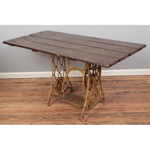 433 - A garden table with cast iron Singer sewing machine treadle base. (75cm x 145cm x 74cm)