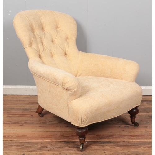 A Howard style cream button upholstered spoon back armchair, raised on Cope and Collinson casters.