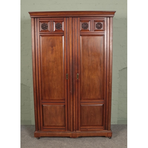 506 - A large mahogany compactum wardrobe with carved doors and plinth top.

Hx203cm
Wx130cm
Dx58cm