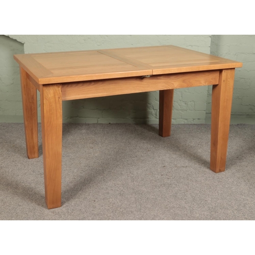 510 - A modern oak extending dining table, with four chairs. Height: 78cm, Width: 130cm (not extended), De... 