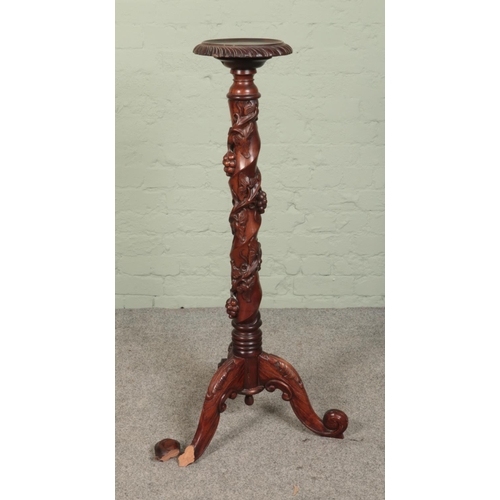 516 - A carved mahogany plant stand/torchere featuring heavily carved floral twist support. Approx. height... 