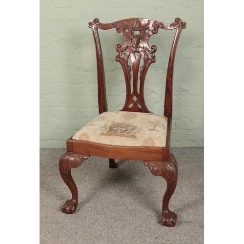 517 - A mahogany pierced back chair with upholstered cushion seat and lion paw feet.