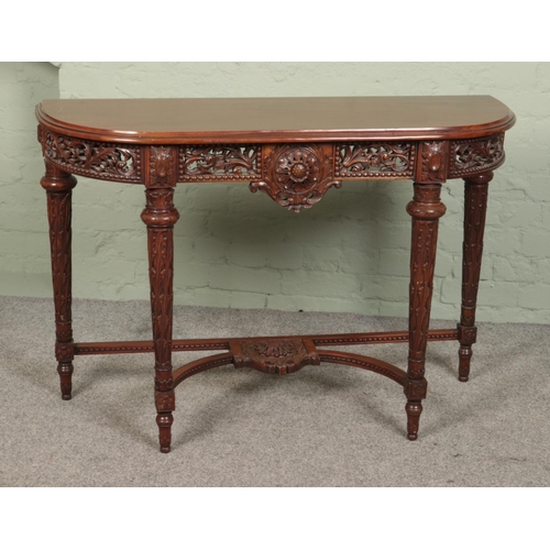 519 - A heavily carved mahogany console table featuring floral motifs. Approx. dimensions 120cm x 44cm x 8... 