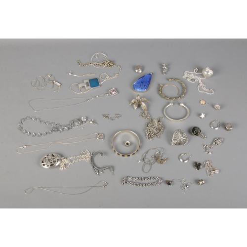 110 - A collection of white metal costume jewellery to include mother of pearl bangle, dragon ear cuff, pe... 