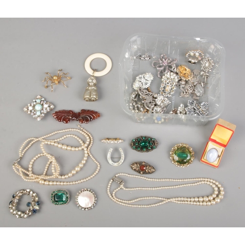 156 - A quantity of costume jewellery. Includes silver ring, brooches, charm bracelet, simulated pearls, e... 