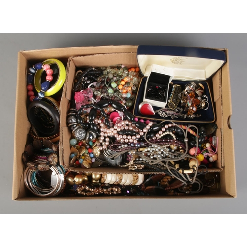 161 - A box of assorted costume jewellery. To include bangles, beaded necklaces, rings and brooches etc.