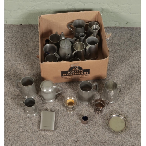 181 - A box of assorted pewter and silver plate to include tankards, candlesticks, flasks etc.