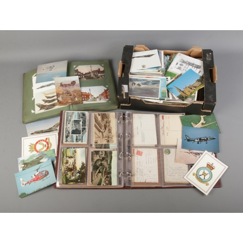 184 - A large box and two albums of vintage postcards including military and aviation subjects.