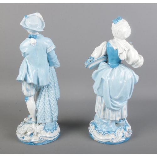 65 - Two Charles Levy Co. blue and white painted porcelain figures depicting a fruit carrier and a fisher... 