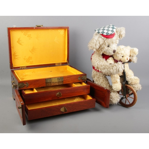 77 - A hardwood jewellery box with brass decoration, together with two bears riding a bicycle.