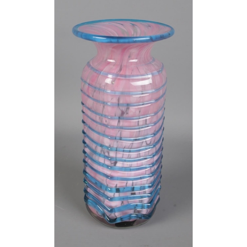 86 - A pink Mdina Maltese glass vase featuring blue trailed pattern to exterior. Approx. height 20.5cm.