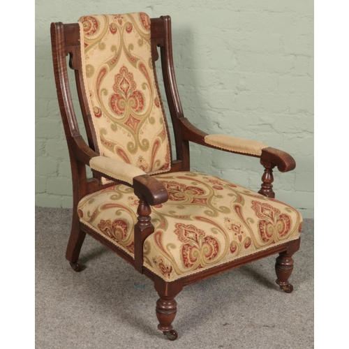 496 - A carved oak upholstered armchair.