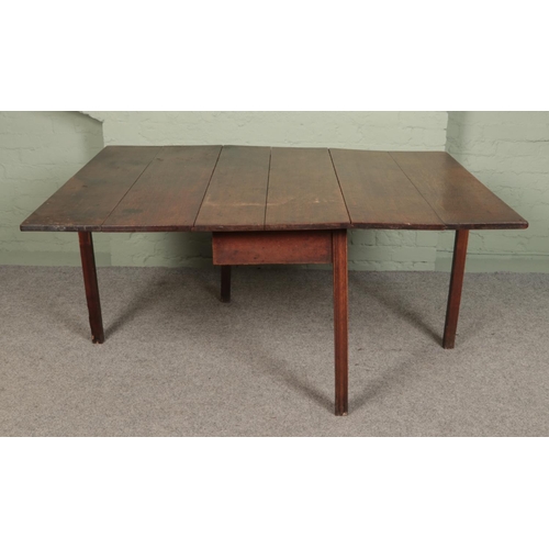 500 - A large Georgian oak drop leaf dining table with gateleg base. Height: 72cm, Width (fully extended):... 