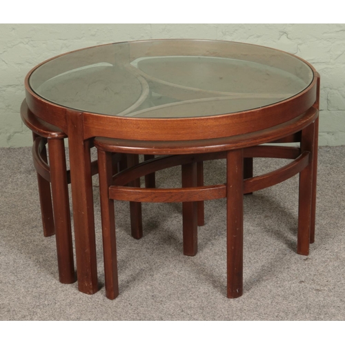 501 - A retro stained teak Nathan Trinity style glass topped coffee table, with three smaller elliptical t... 