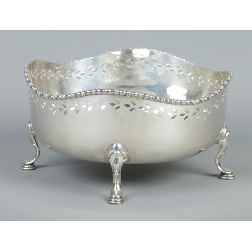 74 - A George V pierced silver bowl raised on four scrolled feet. Assayed Sheffield 1920 by Walker & Hall... 