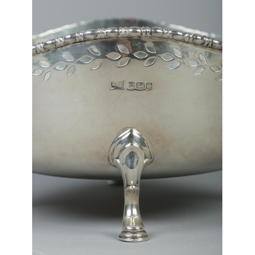 74 - A George V pierced silver bowl raised on four scrolled feet. Assayed Sheffield 1920 by Walker & Hall... 