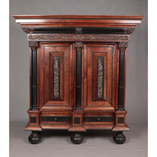 189 - A rosewood and ebonised Schrank with applied carved decoration in the Baroque style. Having two pane... 