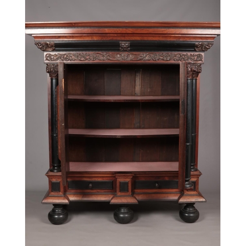 189 - A rosewood and ebonised Schrank with applied carved decoration in the Baroque style. Having two pane... 