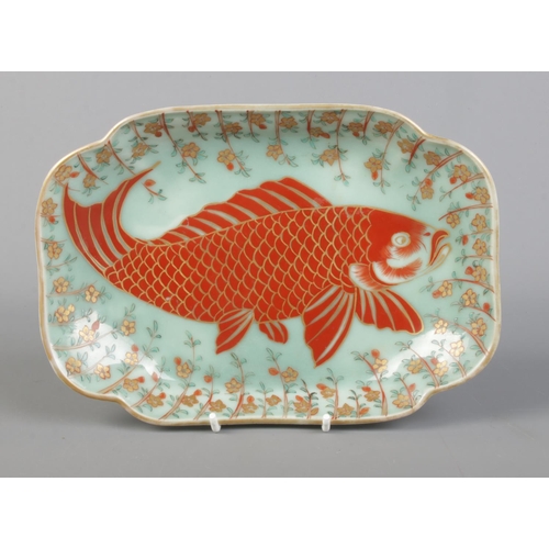 33 - A Japanese quatrefoil shaped dish decorated with a carp on celadon background. Bearing marks in unde... 