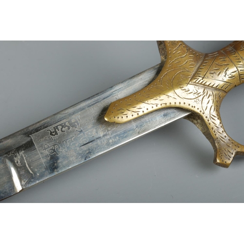 47 - An Indian Tulwar sword with engraved brass handle. The sheath bearing presentation inscription for B... 