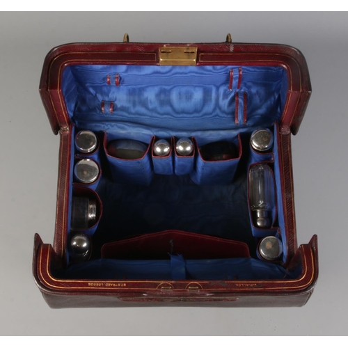 60 - A late 19th/early 20th century leather dressing bag, with blue silk lining and fitted compartments f... 