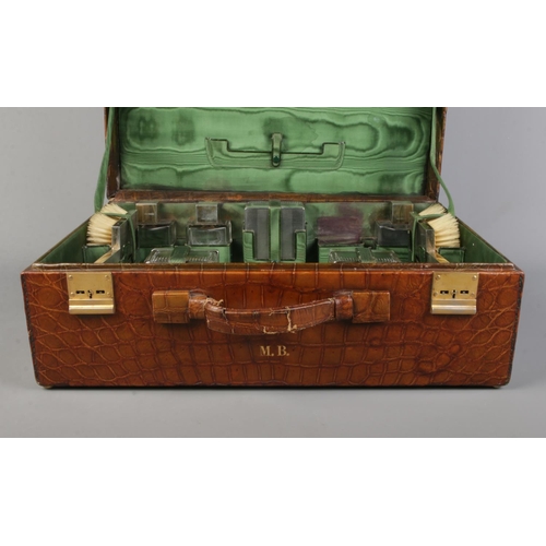 62 - A crocodile skin dressing case by JW Robinson & Co, Los Angeles, with fitted interior and contents o... 