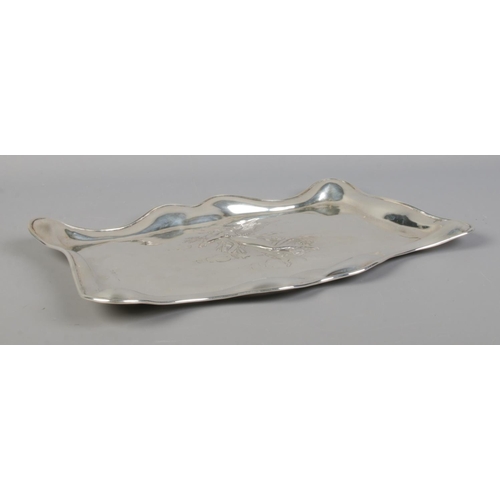 69 - An Edwardian silver dressing table tray with embossed decoration depicting an angel with child. Assa... 