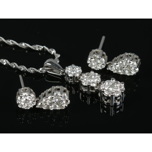 87 - A 14ct white gold and diamond cluster jewellery suite, consisting of drop pendant on chain and pair ... 
