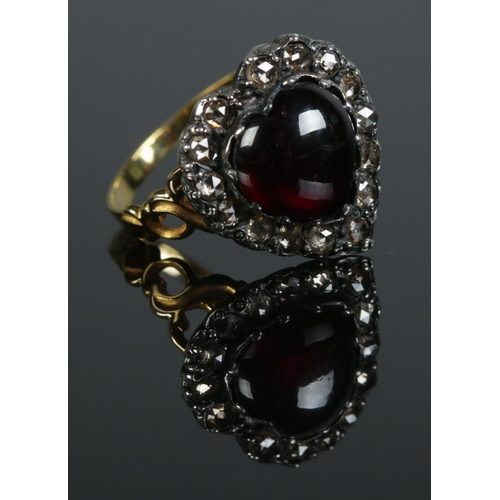 94 - A gold dress ring of heart shape, with central cabochon garnet and diamond surround. Size N 1/2. 4.1... 