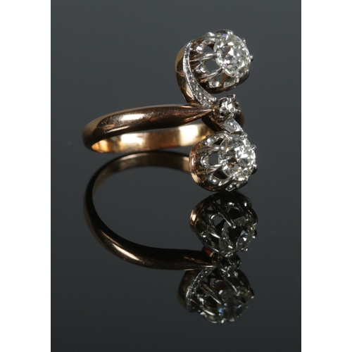 95 - An antique gold two stone diamond ring. Each stone approximately 0.5ct. Size L 1/2. 4.94g.