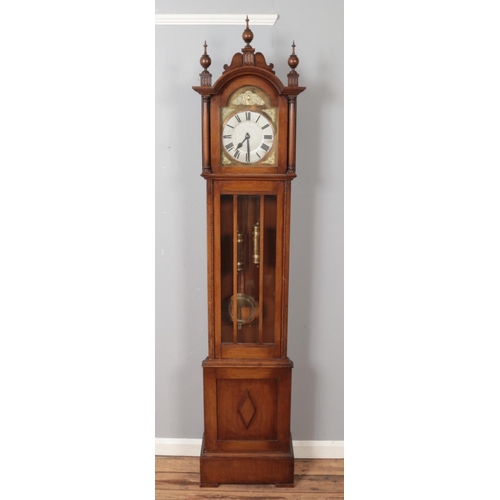 493 - A carved oak longcase clock with turned finials. (211cm x 45cm)