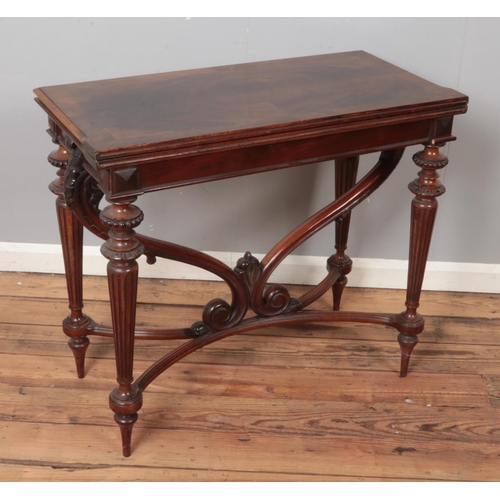 499 - A carved mahogany fold over tea table. Raised on scrolled support and reeded tapering legs. (78cm x ... 