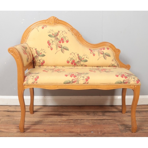 514 - A child's hardwood chaise lounge, with curved back, carved detailing and fabric upholstery depicting... 