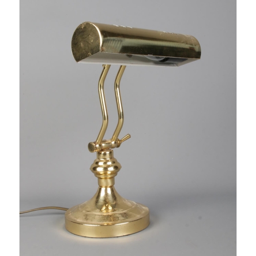 277 - A vintage brass articulated desk light with cylindrical curved shade.