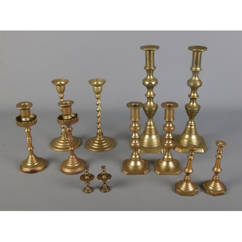 331 - A collection of brass candlestick pairs of varying sizes to include twisted stem examples.