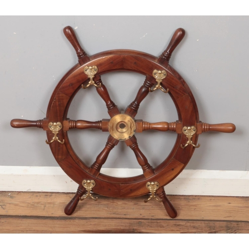 366 - A wooden ships wheel with brass mounted hooks.