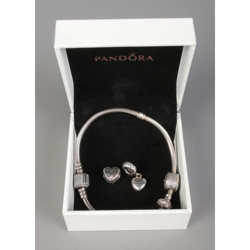 405 - A boxed pandora charm bracelet featuring four silver charms.