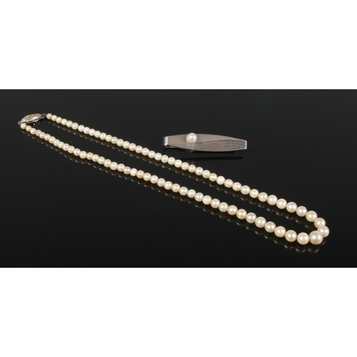 412 - A silver Mikimoto Tokyo tie slide, together with a string of cultured pearls.