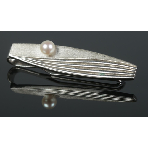 412 - A silver Mikimoto Tokyo tie slide, together with a string of cultured pearls.