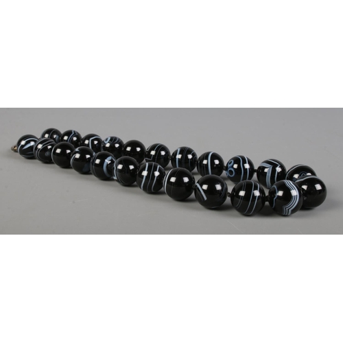 413 - A banded agate necklaces, comprised of twenty three spherical beads.