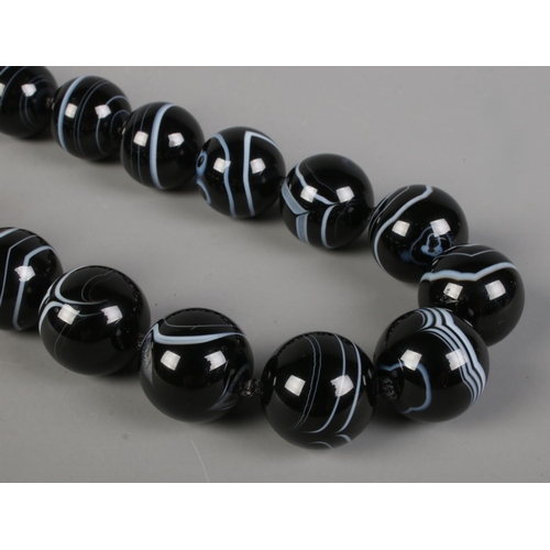 413 - A banded agate necklaces, comprised of twenty three spherical beads.