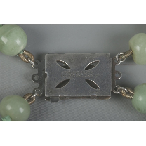 414 - A two row string of jade beads, set with Sterling silver clasp.