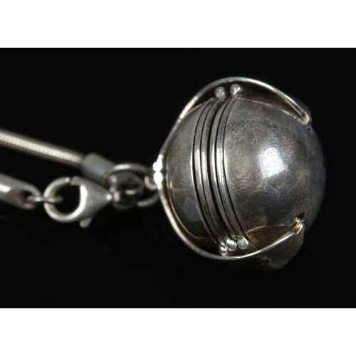 416 - A silver spherical locket and chain, with import marks for London, 1994 with four folding photograph... 