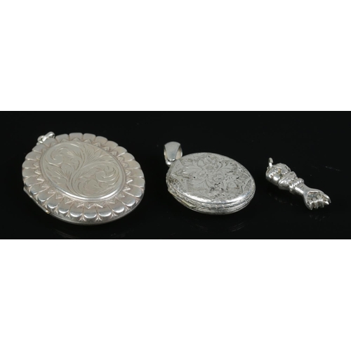 422 - Two silver hinged lockets, together with a small silver amulet in the form of a clenched fist. Total... 